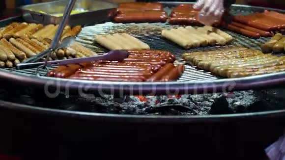 香肠和炸薯条在假日市场上的大金属网上烧烤视频的预览图