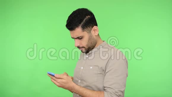 严肃细心的黑发男子穿着衬衫滚动社交媒体或在手机上阅读信息视频的预览图