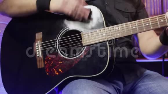 在室内弹声吉他的人男人的手弹声吉他视频的预览图