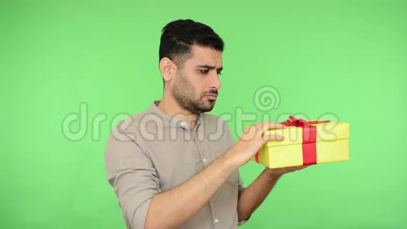 一个头发蓬乱的黑发男人穿着衬衫打开礼物看着里面的盒子厌恶地转身离开视频的预览图