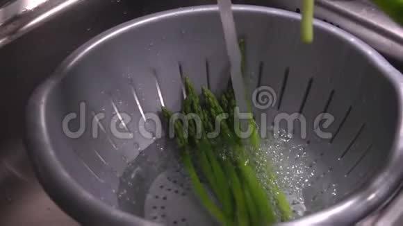 煮熟的绿芦笋长矛落在冷水中视频的预览图