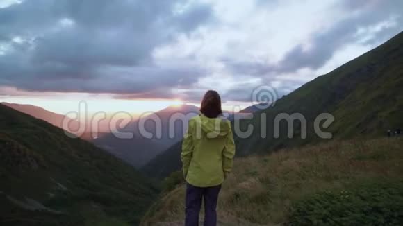 日落时一个女孩从山上欣赏风景前景中女孩的头视频的预览图