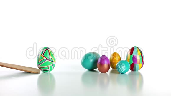 传统的基督教复活节游戏女性手拿一个彩蛋从木板上滚到一组复活节彩蛋视频的预览图