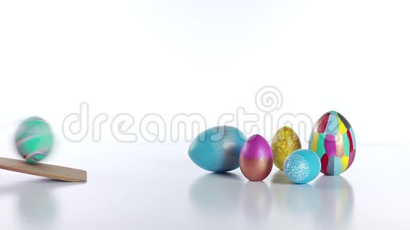 复活节彩蛋卷鸡蛋从木板上滚下来打在白色桌子上的其他鸡蛋传统基督教复活节游戏视频的预览图