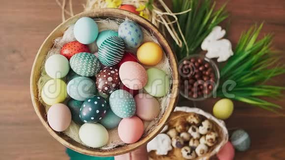 双手提着装满五颜六色的复活节彩蛋的篮子摆在木桌上复活节节日装饰品复活节视频的预览图