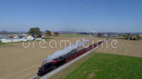 一辆旧的蒸汽机车乘用车在乡间穿梭视频的预览图
