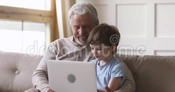 快乐的老爷爷和孙子用笔记本电脑打电话视频的预览图