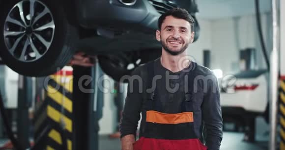 一位来自汽车服务中心的快乐机械师在镜头前直视着微笑享受着时光视频的预览图