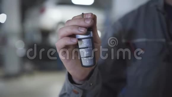 特写男性白种人手拿车钥匙穿着工作服的成年男子在镜头前展示汽车故障的钥匙视频的预览图