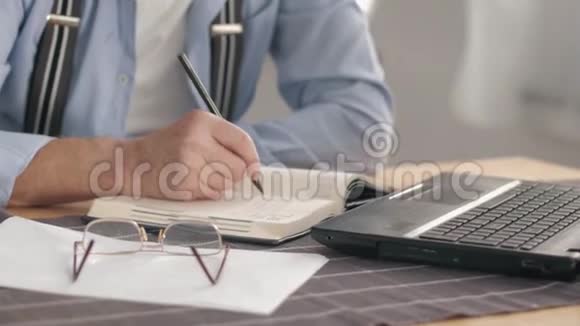 退休老人在网上计算公用事业账单在笔记本上写数据在坐在笔记本电脑上工作视频的预览图