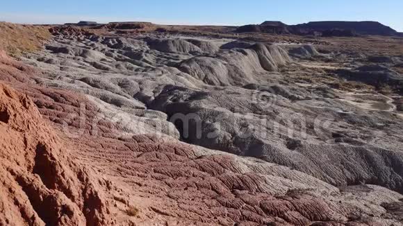 在阳光明媚的日子里画的沙漠不同的沉积岩和粘土被水冲走美国石化森林国家公园视频的预览图