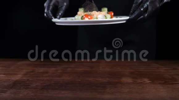 健康的食物和精致的餐厅菜肴黑手套厨师拿着黑色背景的熟鞑靼视频的预览图