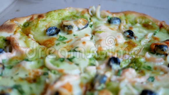 手拿美味的新鲜披萨配贻贝橄榄奶酪视频的预览图