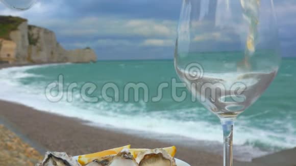 白葡萄酒倒在牡蛎旁边的玻璃杯里视频的预览图