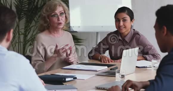 技术熟练的老女导师教授员工小组举办企业讲习班视频的预览图