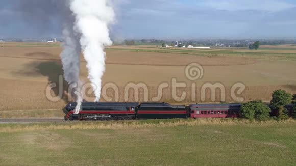恢复后的蒸汽机在拉客车时吹汽和冒烟的侧视图视频的预览图