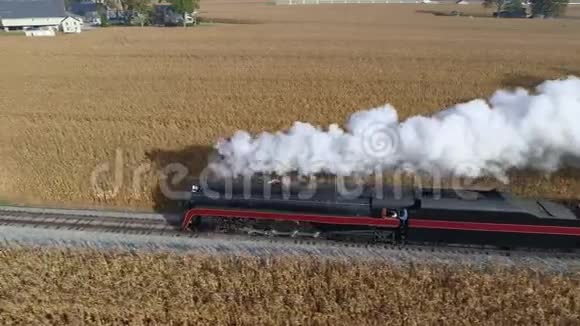 恢复后的蒸汽机在拉客车时吹汽和冒烟的侧视图视频的预览图