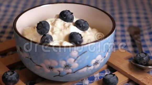 把蓝色浆果放在碗里的酸奶上视频的预览图