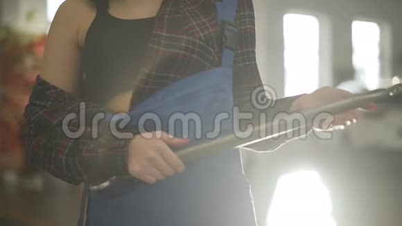 女性高加索手的特写无法辨认的年轻女子站在汽车修理厂的阳光下视频的预览图