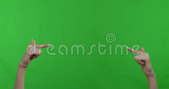 女性双手指着绿色彩色背景上的空空间视频的预览图