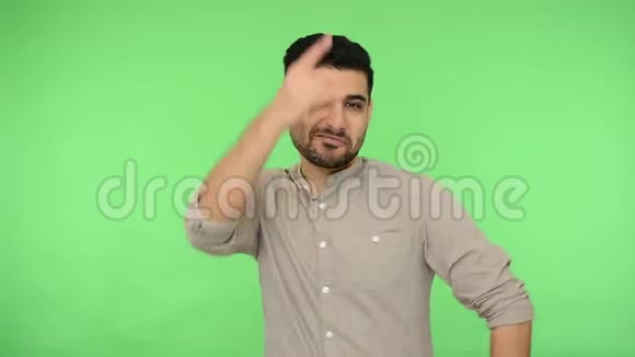 热情疯狂的黑发男人穿着衬衫展示摇滚标志的手势绿色背景色度键视频的预览图