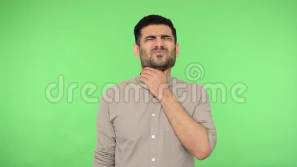 喉咙痛不健康的年轻人穿着衬衫摩擦脖子痛苦地做鬼脸绿色背景色度键视频的预览图