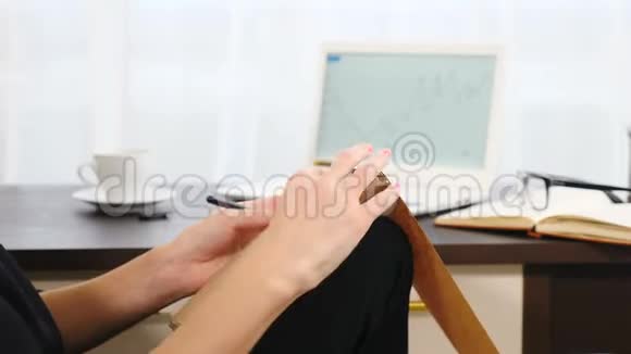 女人在笔记本上写字特写镜头商务女性穿着黑色衣服坐在酒店房间里用记事本写笔记视频的预览图