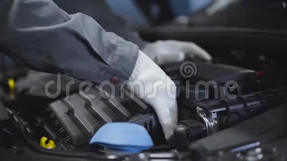 在白色防护手套中特写男性手检查汽车内部自动机械师手动检查打开的引擎视频的预览图