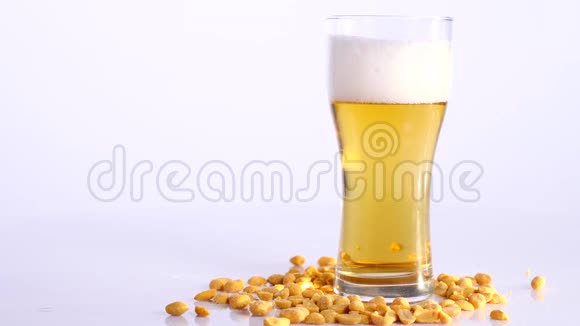 啤酒倒在白色背景的玻璃里上面有泡菜花生视频的预览图