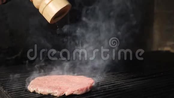 慢动作食物视频汉堡包烹饪在烤炉上放上新鲜的汉堡馅饼因为胡椒粉被洒在上面视频的预览图