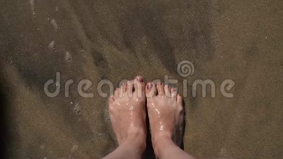 女人的腿在沙滩上海水和日落视频的预览图
