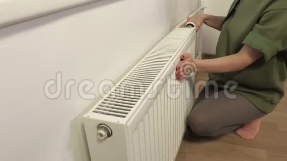 女人检查暖气片的暖化视频的预览图