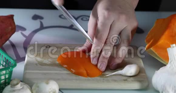 女人在厨房的木板上切橙胡椒女性手准备一份带有甜椒的沙拉健康视频的预览图