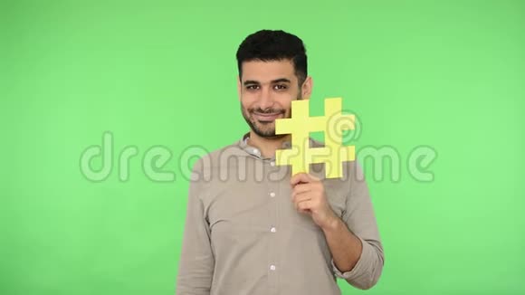 互联网普及微笑的黑发男子指向黄色标签符号并显示拇指向上色度键视频的预览图