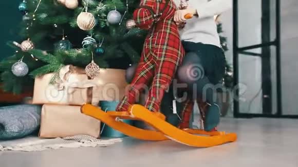 女孩骑在圣诞树附近的玩具马上视频的预览图
