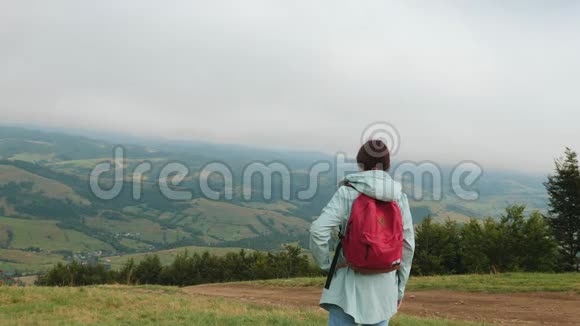 徒步旅行者夫人背着背包在山上寻找视频的预览图