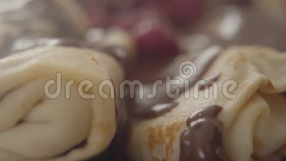 在烤薄饼上滴着巧克力馅美味的甜点上面放着浆果和糖浆视频的预览图
