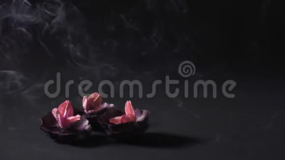干燥的花和云的芳香烟雾在黑暗的背景下健康与冥想东方疗法视频的预览图