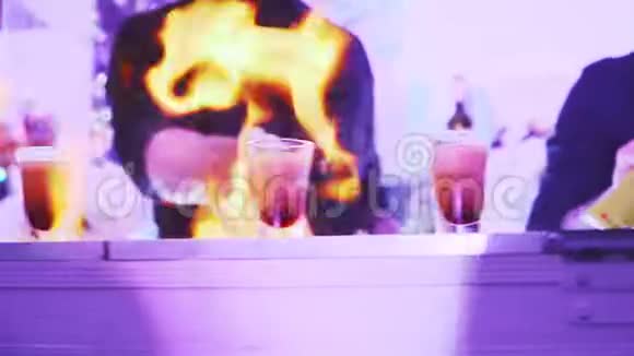 酒保在晚会上准备鸡尾酒用酒精饮料点燃玻璃杯慢动作特写视频的预览图