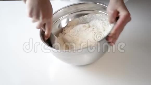 女人混合配料做饼干面包师用鸡蛋糖和面粉在白色桌子上的碗里准备面团视频的预览图