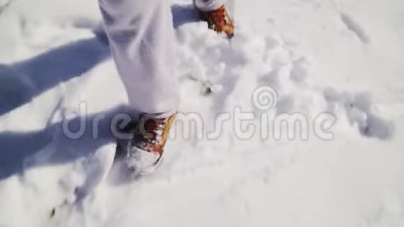 特写镜头男人穿着雪棕色的冬靴和灰色的运动裤雪冬天的气氛视频的预览图