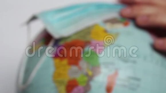 女性双手戴着地球仪上的医疗面罩世界检疫标志视频的预览图