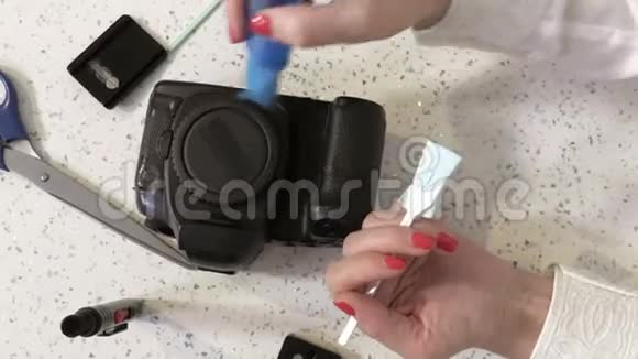 女摄影师清洗脏摄像头传感器视频的预览图