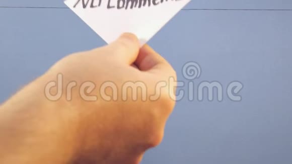 一个人挂着一张白纸上面写着黑色的铭文在蓝色的背景上没有任何评论视频的预览图