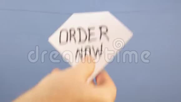 一个男人挂着一张白纸上面有黑色刻字现在在蓝色的背景上视频的预览图