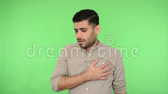 心痛生病的黑发男子抓住他的胸部呼吸困难感觉不舒服绿色背景色度键视频的预览图