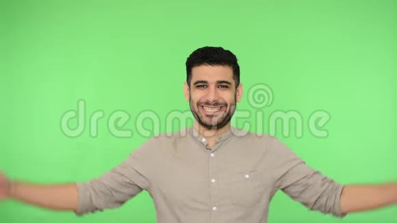 兴奋快乐的男人做房子标志屋顶手势超过他的头和微笑满意绿色背景视频的预览图