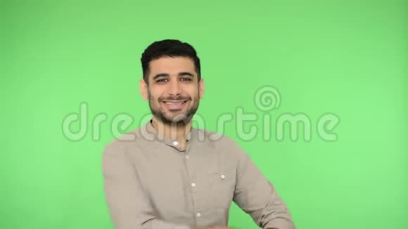 开朗的黑发男子交叉双手和微笑的相机聪明的专家室内演播室拍摄绿色背景色度键视频的预览图