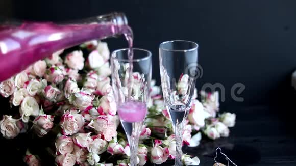 闪闪发亮的覆盆子饮料两个杯子里的香槟放在一张有冰的木桌上为了花和花环视频的预览图