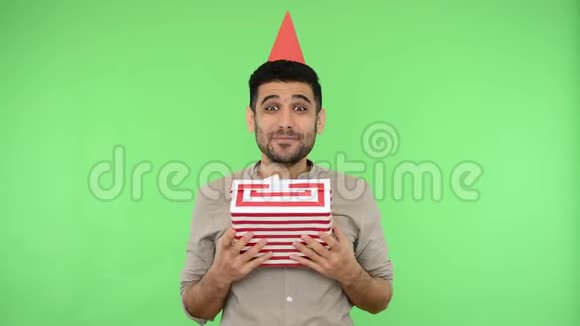 快乐有趣的男人头上戴着派对锥穿着衬衫说生日快乐并送了包裹的礼品盒色度键视频的预览图